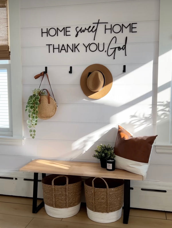 Nestled nook with 'Home sweet home thank you God' sign, wooden bench, baskets, and decor items.